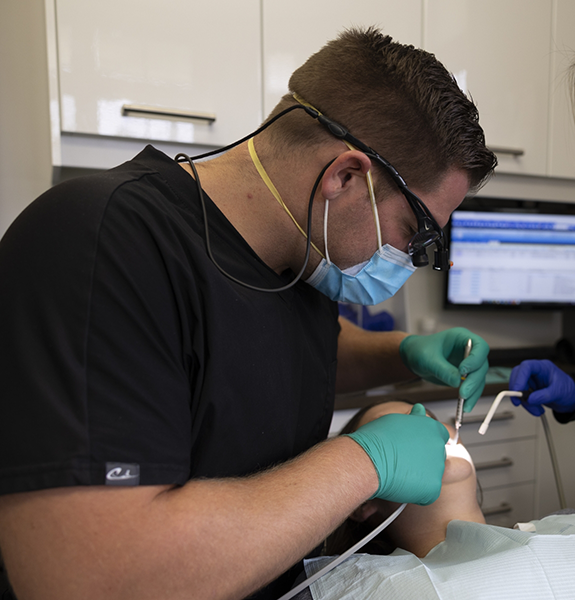 Patient in dental chair smiling at dentist