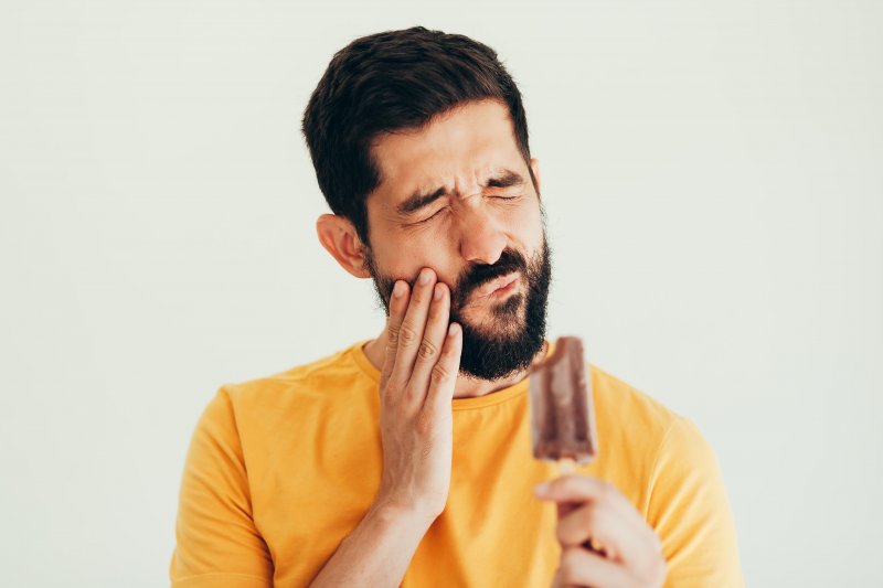 man with sensitive teeth eating a popsicle