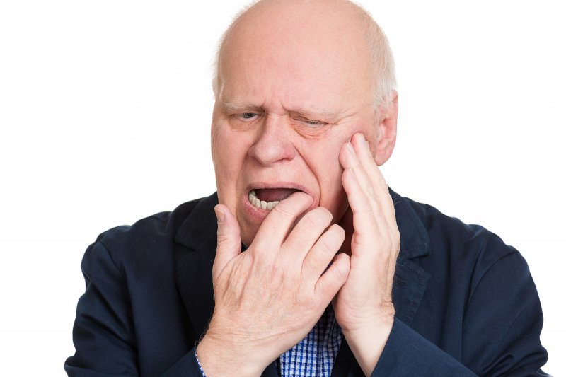 older man dealing with mouth pain